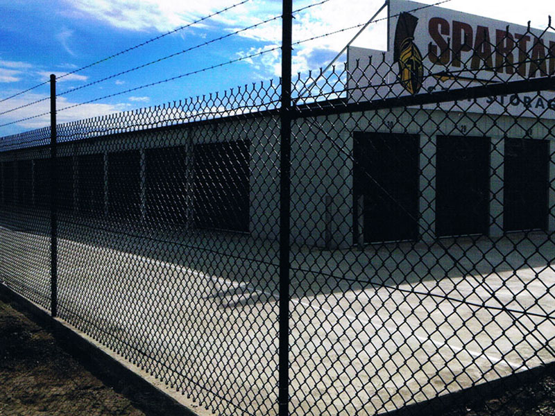 Fencing Wallan-Black chain mesh wire fence with 3 barbed wires on top around factory