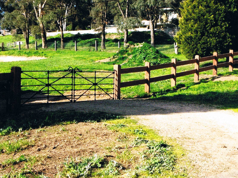 Red gum mortised post and 2 rail fencing with set of Black sunshine gates